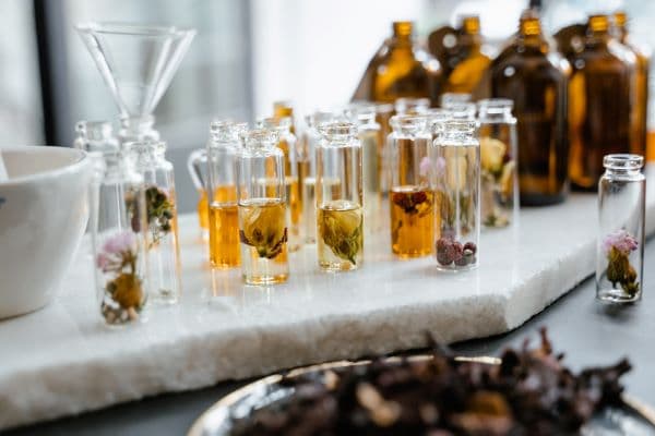 Table avec des fioles d'huiles essentielles et des fleurs